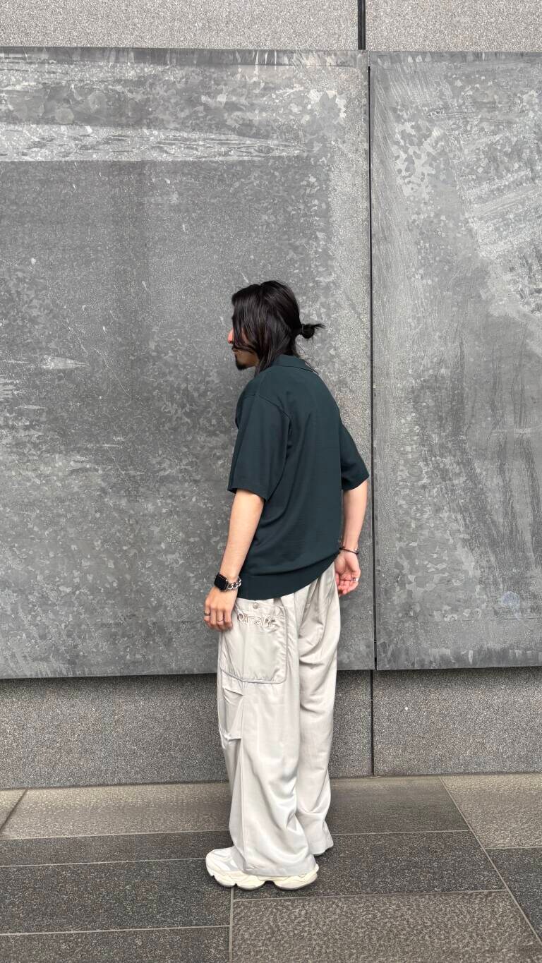 グリーン系のニット/セーター、グレー系のその他パンツを着用したメンズの春コーディネートの2枚目の写真