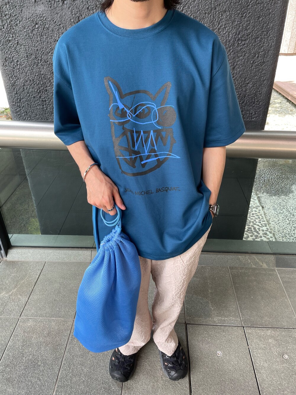 ブルー系のTシャツ/カットソー、ベージュ系のスラックスを着用したメンズの夏コーディネートの3枚目の写真