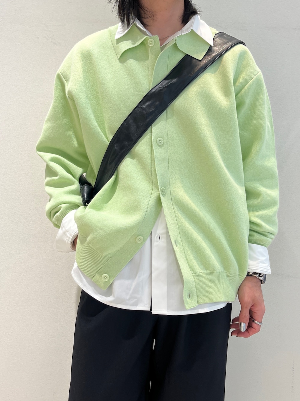 グリーン系のカーディガン/ボレロ、ホワイト系のシャツ/ブラウス、ブラック系のスラックスを着用したメンズの冬コーディネートの2枚目の写真