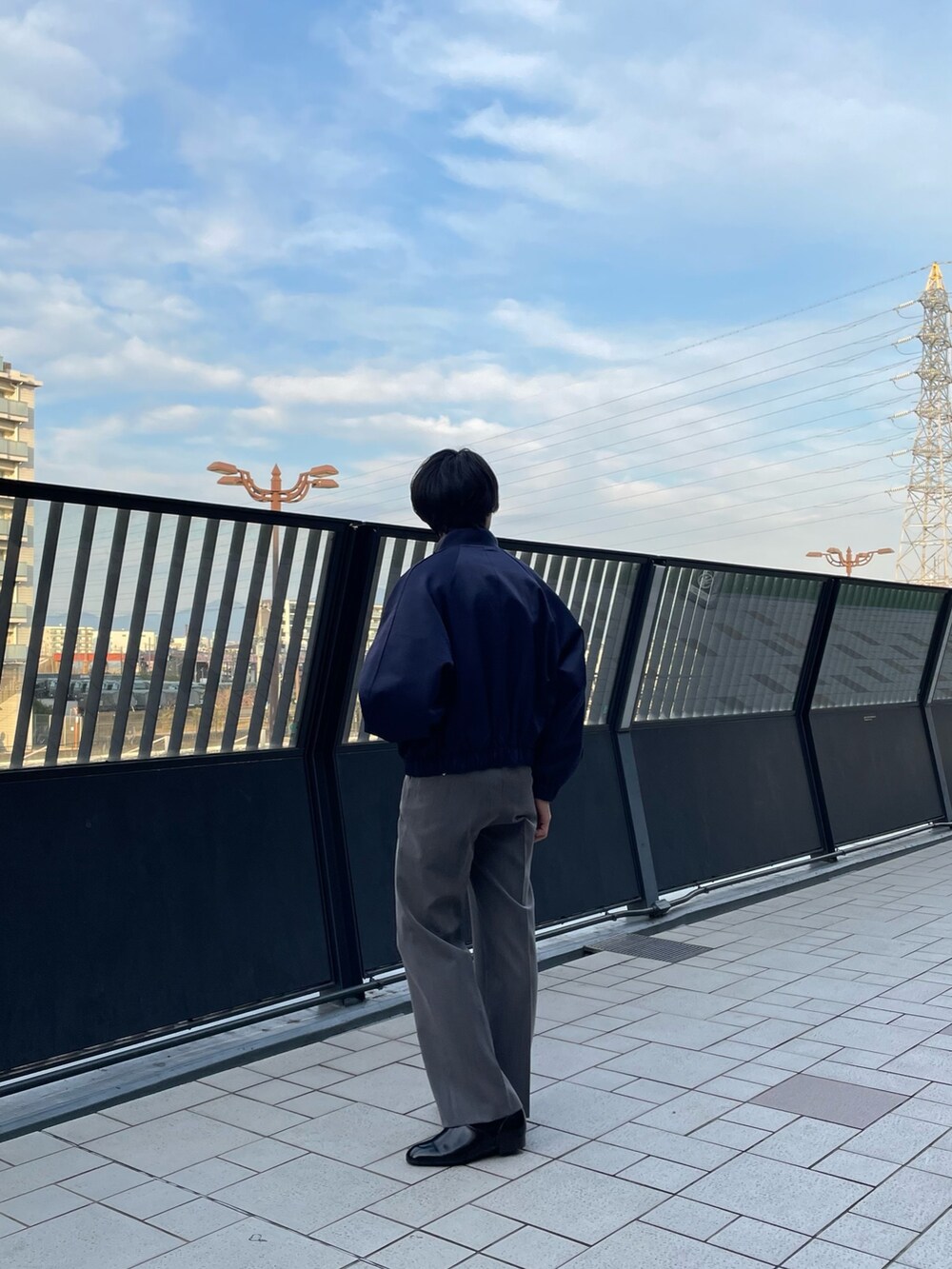 ブルー系のブルゾン、グレー系のスラックスを着用したメンズの春コーディネートの4枚目の写真