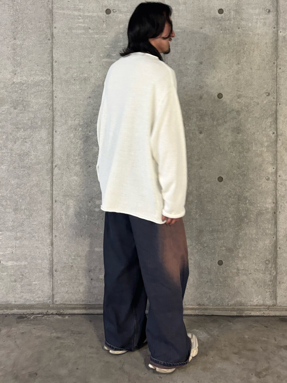 ホワイト系のニット/セーター、ブルー系のデニムパンツを着用したメンズの秋コーディネートの3枚目の写真