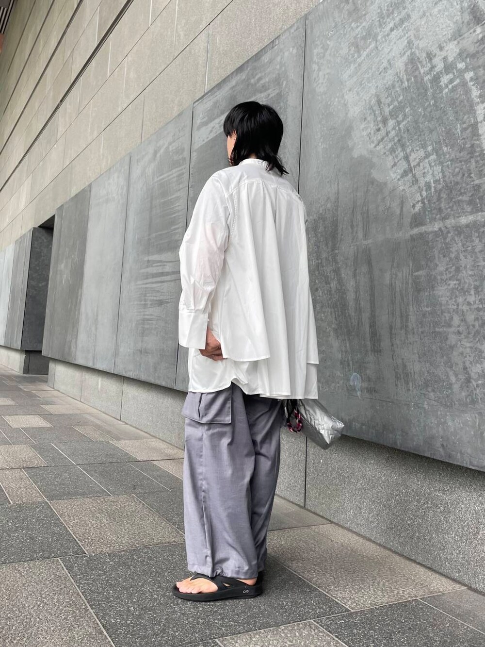 グレー系のカーゴパンツ、ホワイト系のワンピース、シルバー系のハンドバッグを着用したメンズの夏コーディネートの4枚目の写真