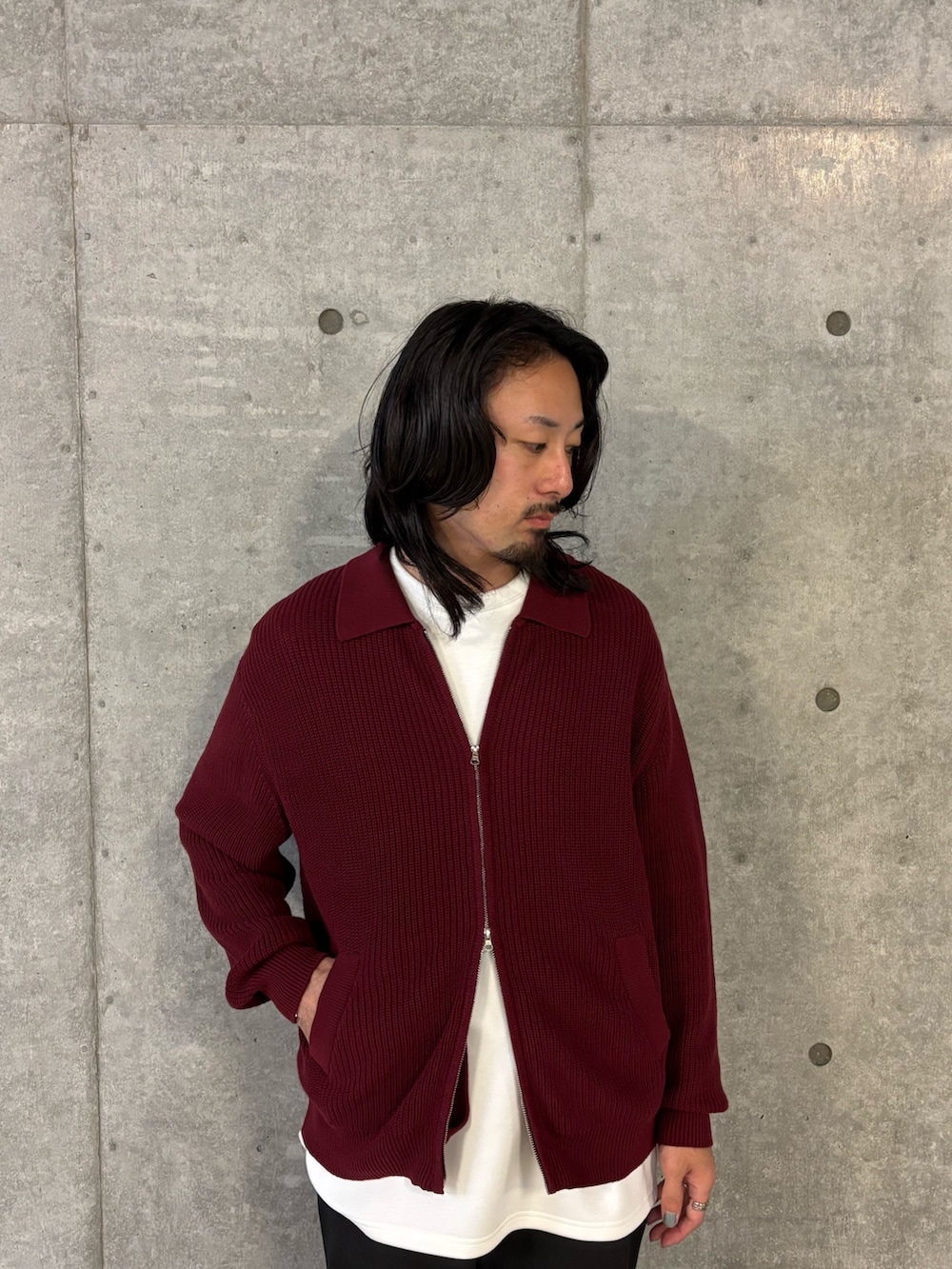 レッド系のニット/セーター、ブラック系のその他パンツを着用したメンズの秋コーディネートの4枚目の写真