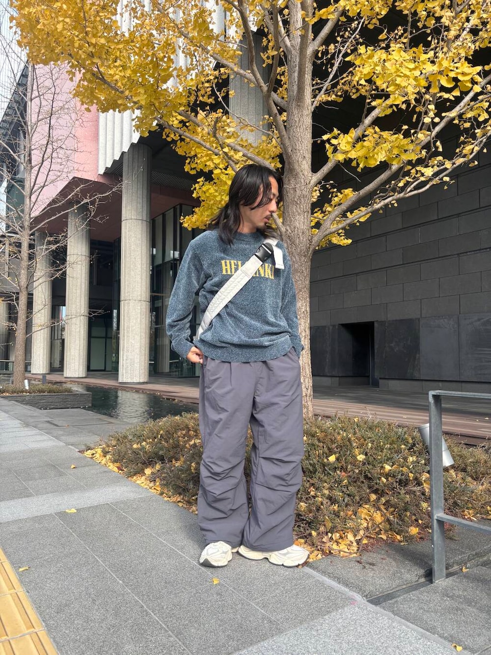 グレー系のショルダーバッグ、グレー系のその他パンツ、ブルー系のニット/セーターを着用したメンズの冬コーディネートの2枚目の写真