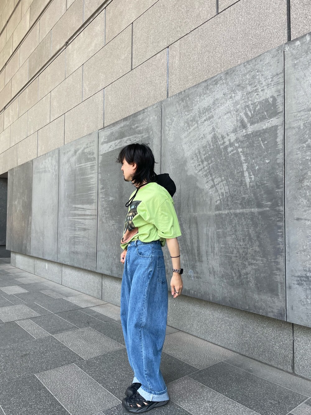 グリーン系のTシャツ/カットソー、ブルー系のデニムパンツ、ブラック系のハットを着用したメンズの夏コーディネートの2枚目の写真