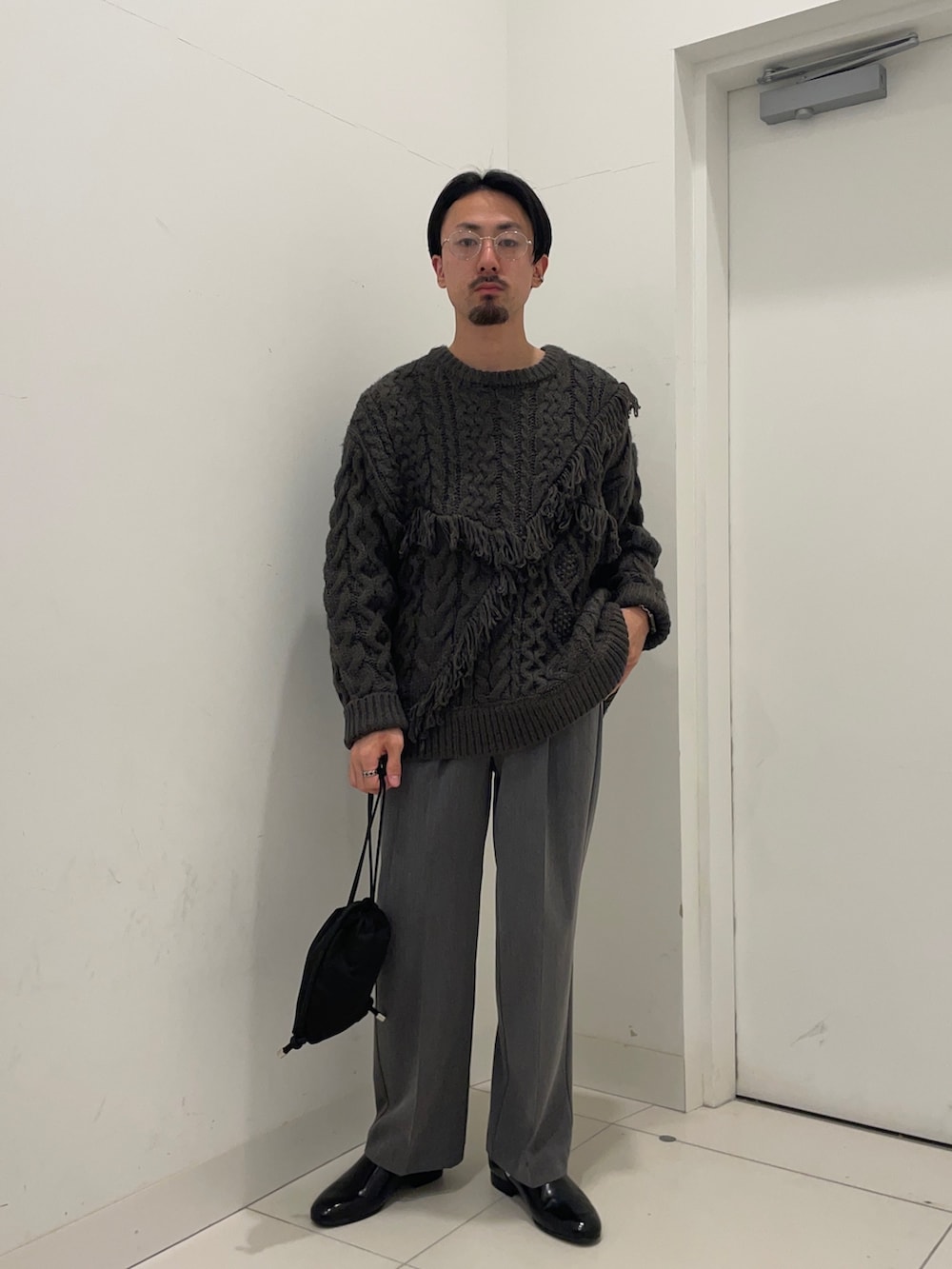 グレー系のニット/セーター、グレー系のその他パンツを着用したメンズの冬コーディネートの2枚目の写真