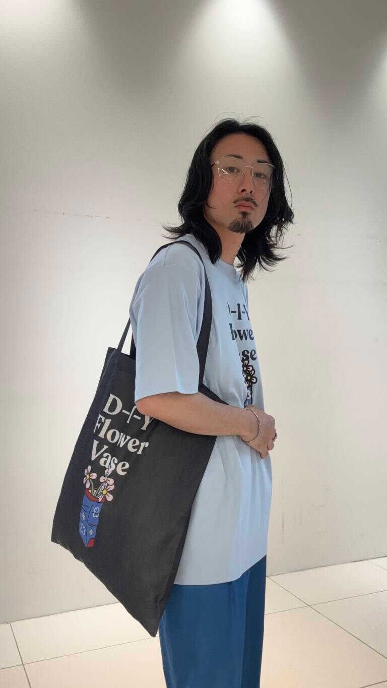 ブルー系のその他パンツ、ブラック系のトートバッグ、ブルー系のTシャツ/カットソーを着用したメンズの春コーディネートの6枚目の写真