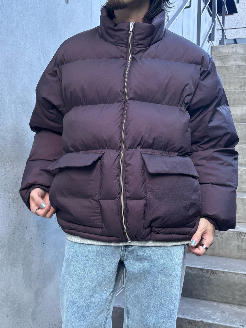 パープル系のブルゾン、ブルー系のデニムパンツを着用したメンズの秋コーディネートの4枚目の写真