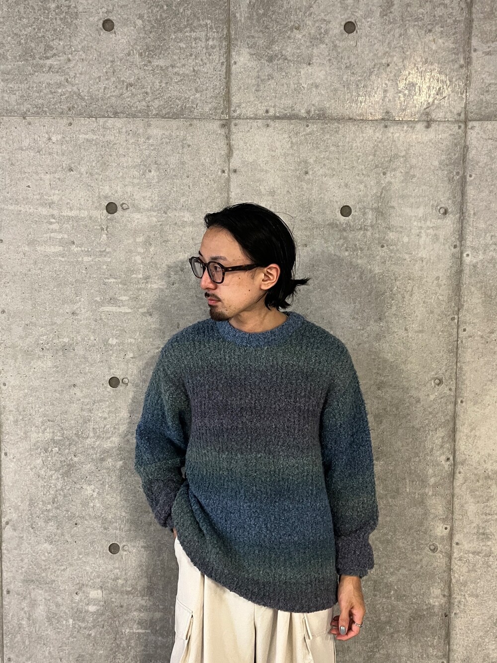 ブルー系のニット/セーター、ホワイト系のその他パンツを着用したメンズの秋コーディネートの5枚目の写真