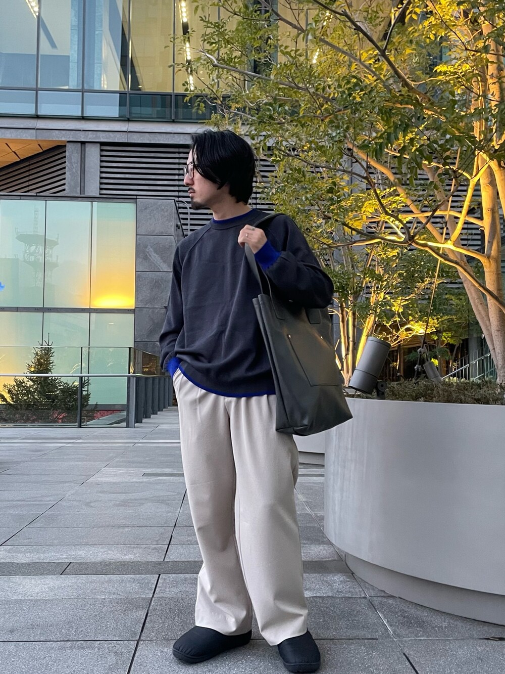 ベージュ系のその他パンツ、グレー系のトートバッグ、グレー系のニット/セーターを着用したメンズの春コーディネートの2枚目の写真