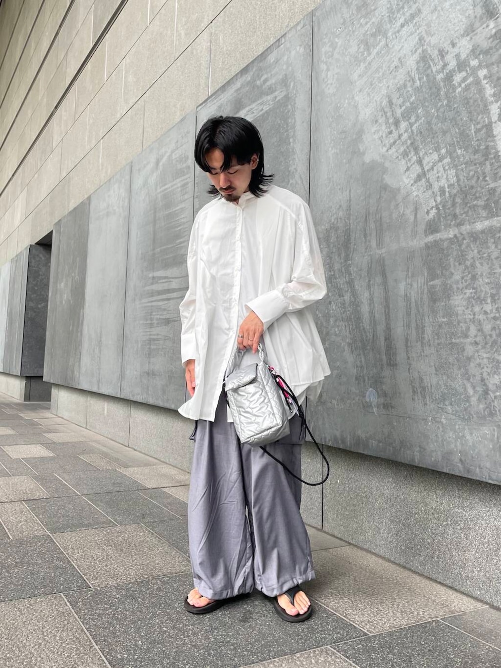 グレー系のカーゴパンツ、ホワイト系のワンピース、シルバー系のハンドバッグを着用したメンズの夏コーディネートの2枚目の写真