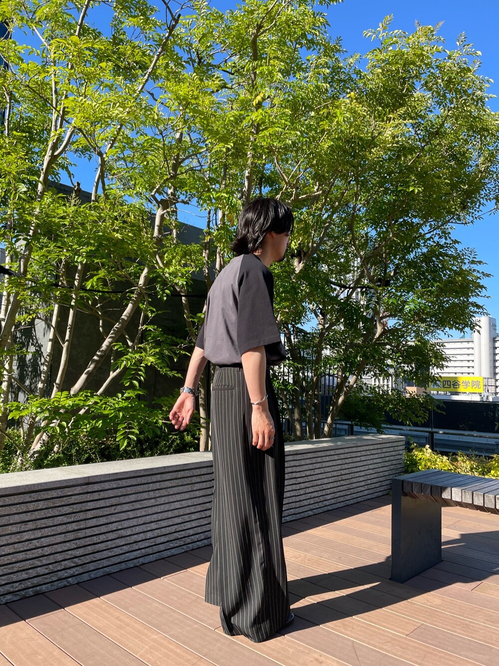 ブラック系のスラックス、ブラック系のTシャツ/カットソーを着用したメンズの夏コーディネートの2枚目の写真