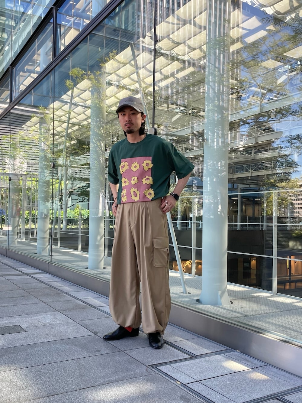 グリーン系のTシャツ/カットソー、ベージュ系のカーゴパンツ、ブラウン系のキャップを着用したメンズの夏コーディネートの2枚目の写真