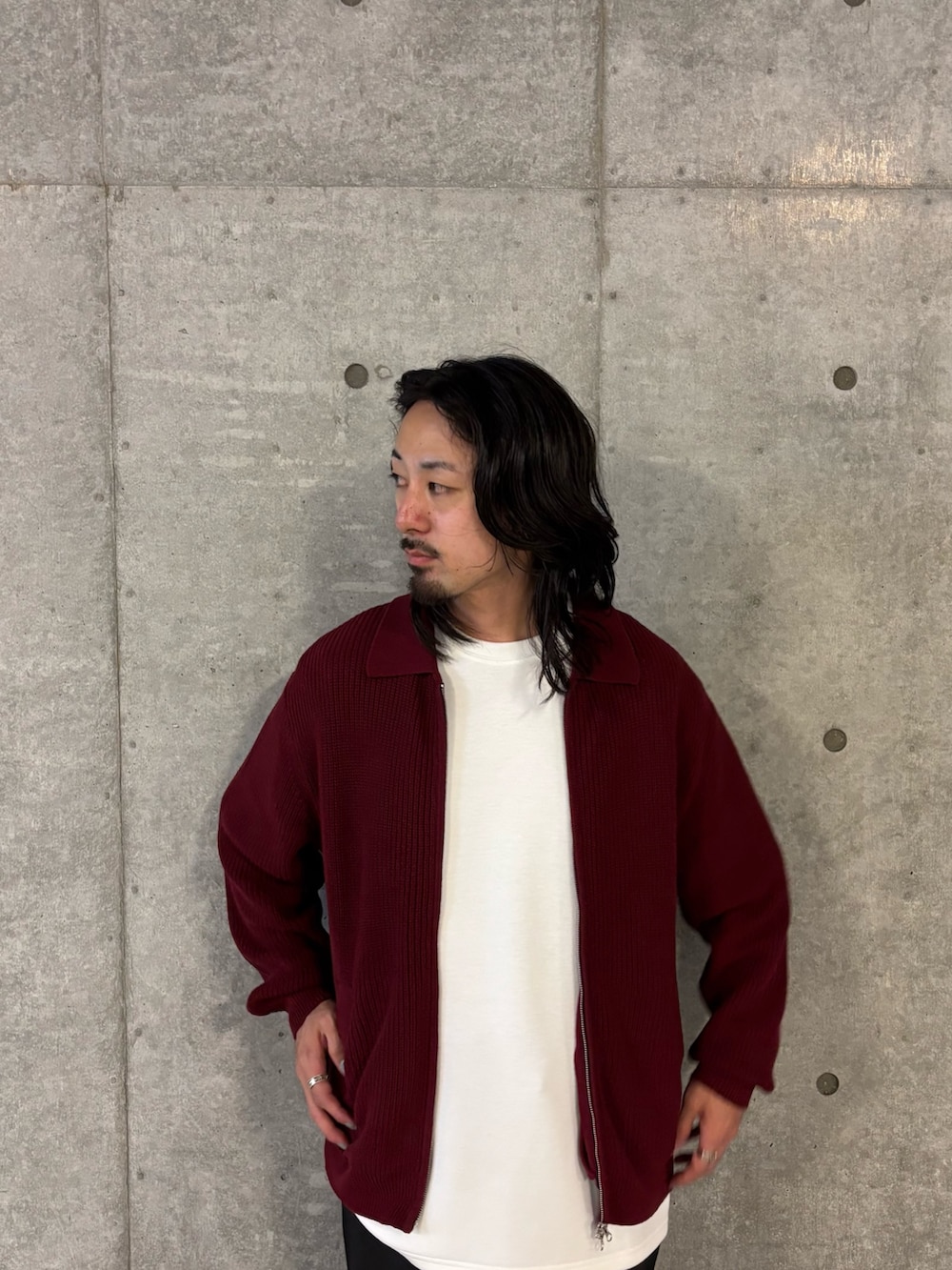 レッド系のニット/セーター、ブラック系のその他パンツを着用したメンズの秋コーディネートの2枚目の写真