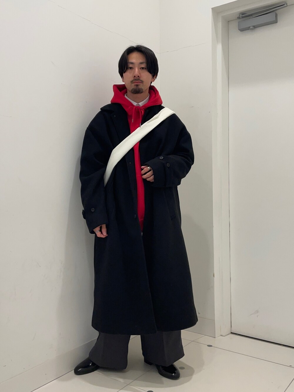 ブラック系のその他アウター、レッド系のパーカー、グレー系のその他パンツを着用したメンズの冬コーディネートの2枚目の写真