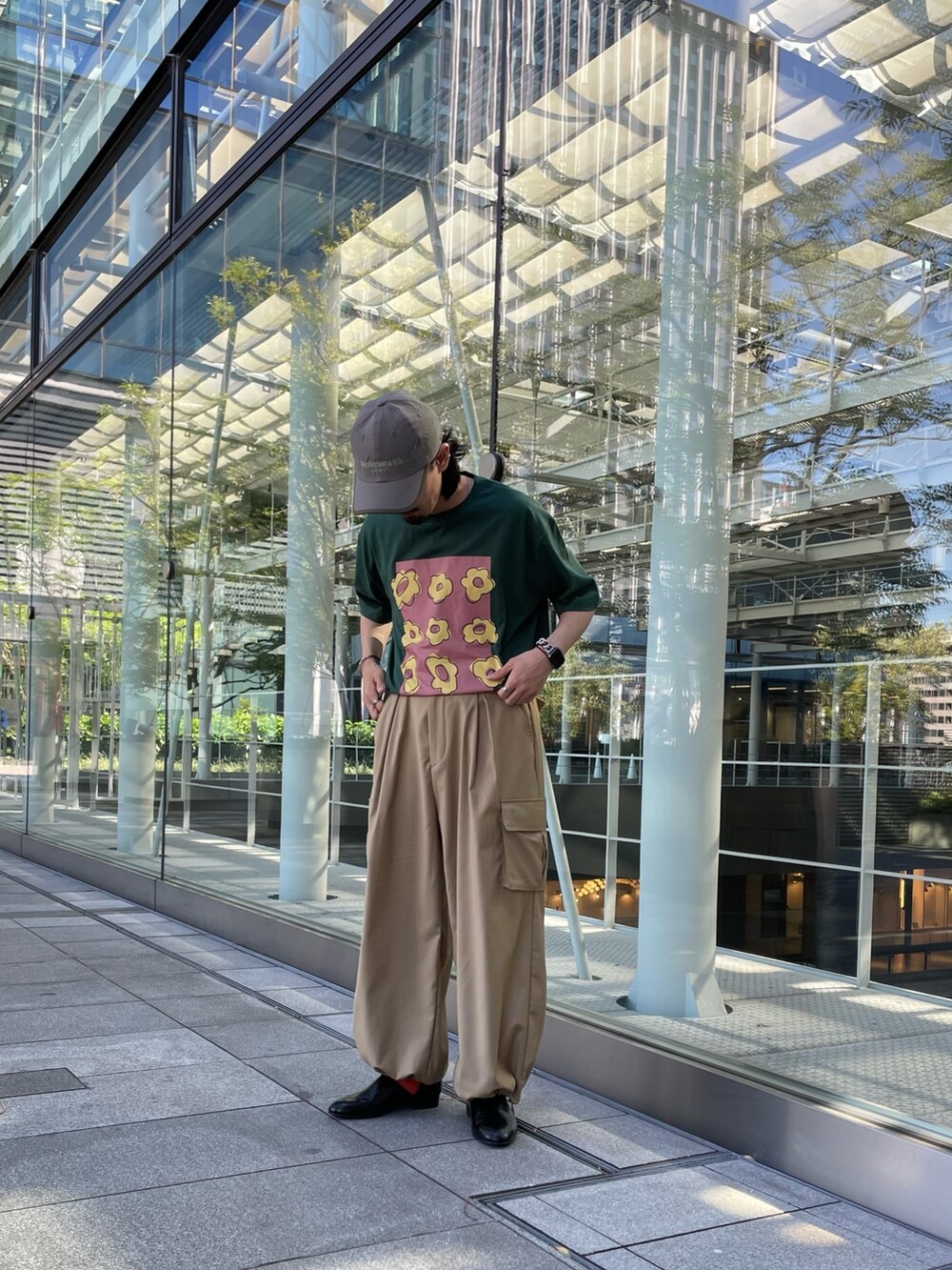 グリーン系のTシャツ/カットソー、ベージュ系のカーゴパンツ、ブラウン系のキャップを着用したメンズの夏コーディネートの3枚目の写真