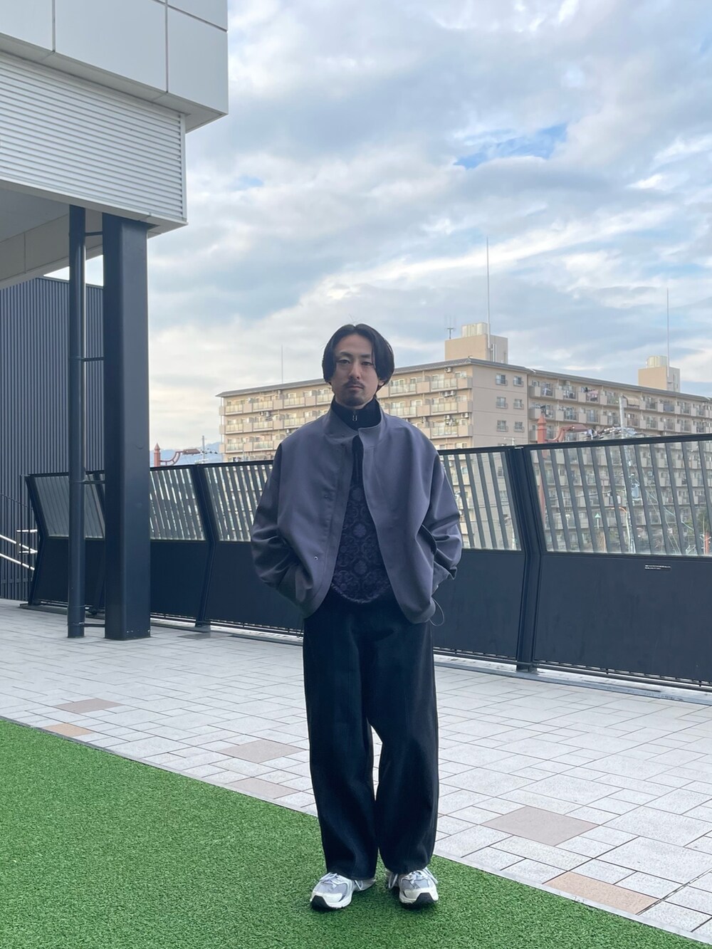 ブルー系のモッズコート、ブラック系のデニムパンツ、ブラック系のニット/セーターを着用したメンズの春コーディネートの3枚目の写真