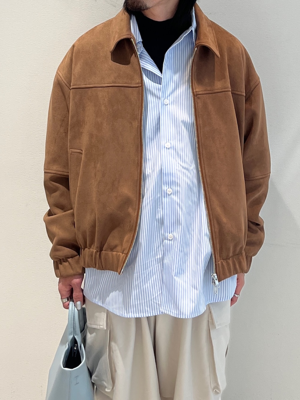 ベージュ系のブルゾン、ブルー系のシャツ/ブラウス、ホワイト系のその他パンツを着用したメンズの冬コーディネートの3枚目の写真