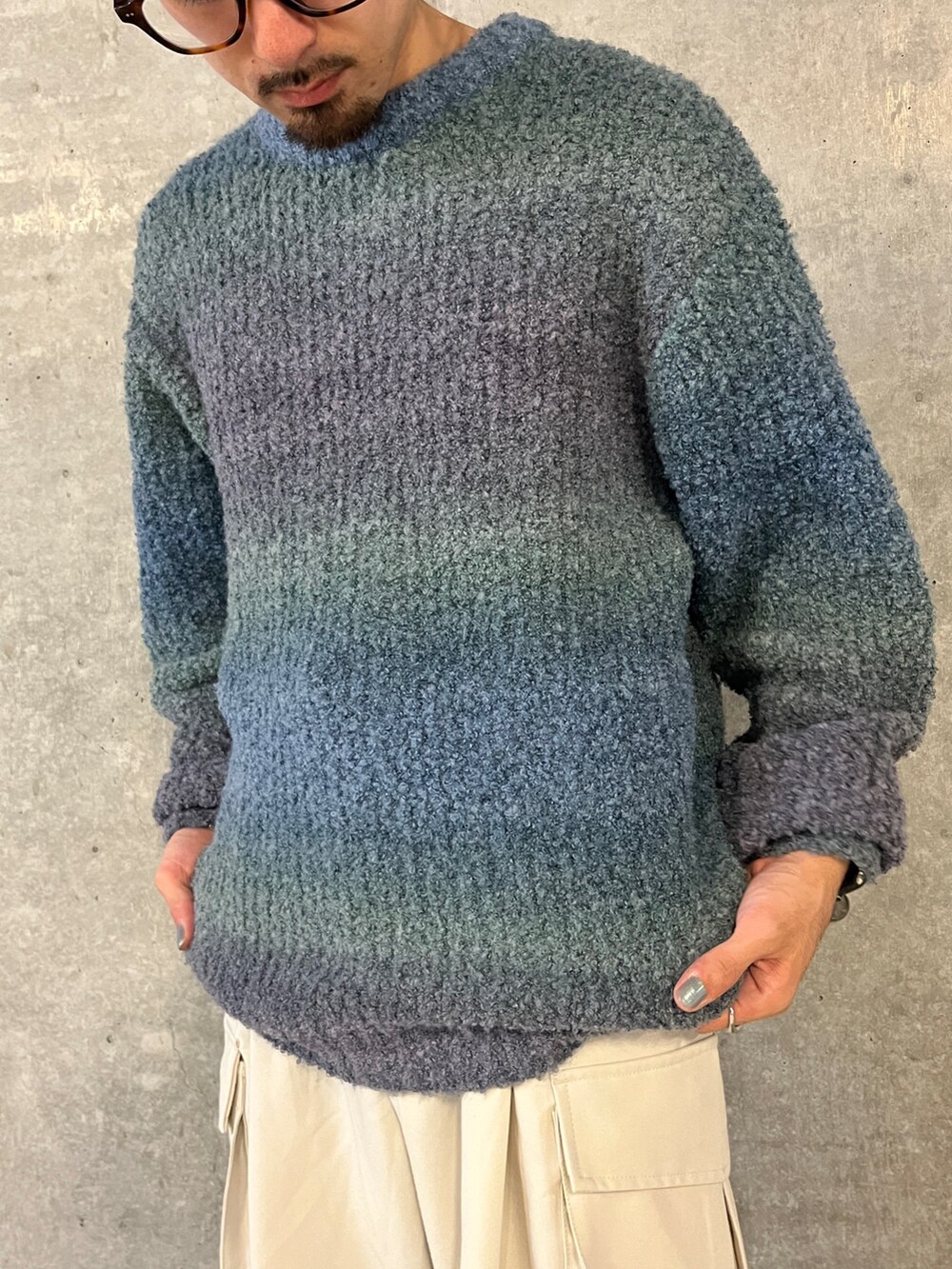 ブルー系のニット/セーター、ホワイト系のその他パンツを着用したメンズの秋コーディネートの4枚目の写真