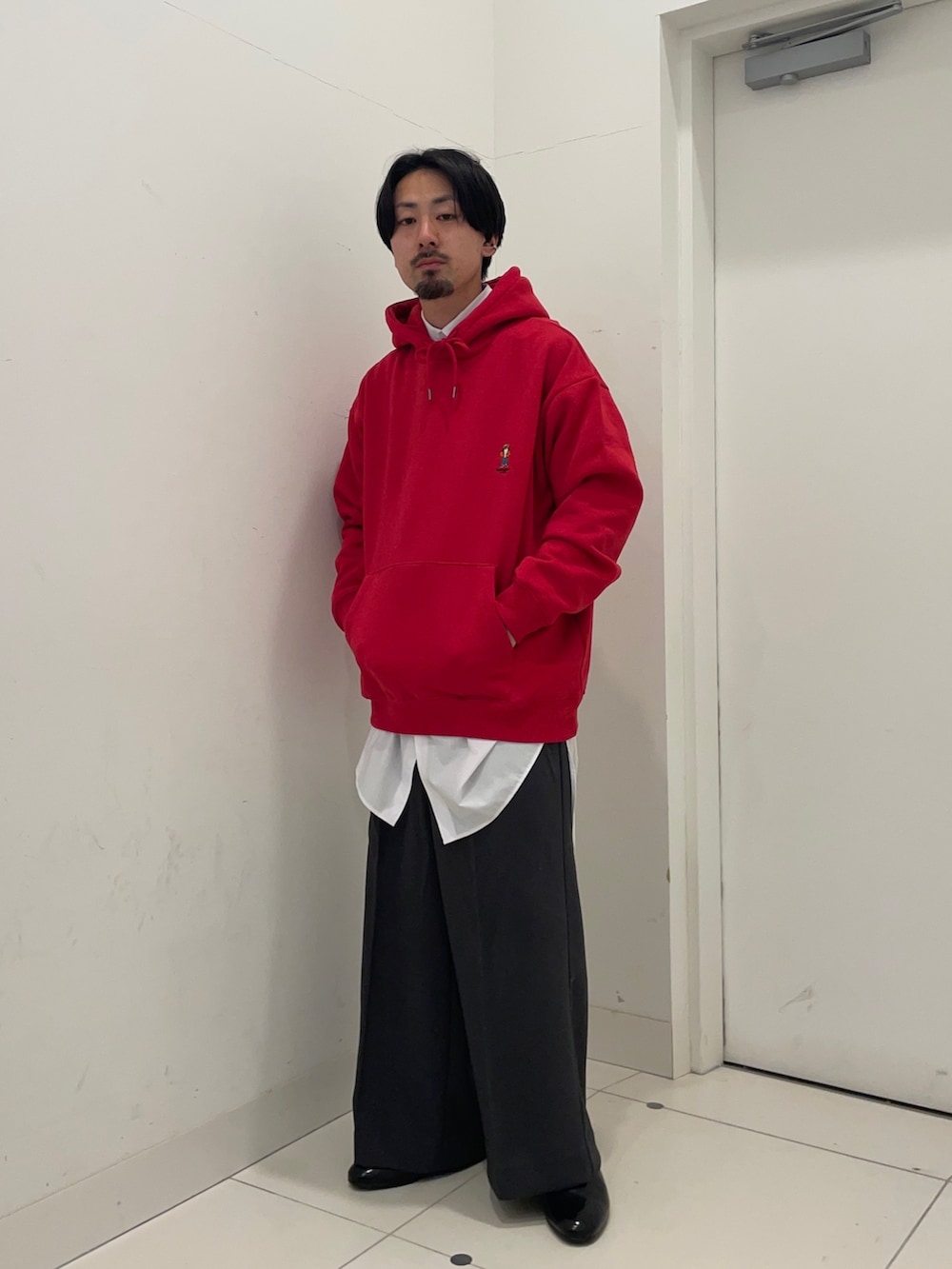 レッド系のパーカー、ベージュ系のその他パンツ、グレー系のシャツ/ブラウスを着用したメンズの冬コーディネートの3枚目の写真