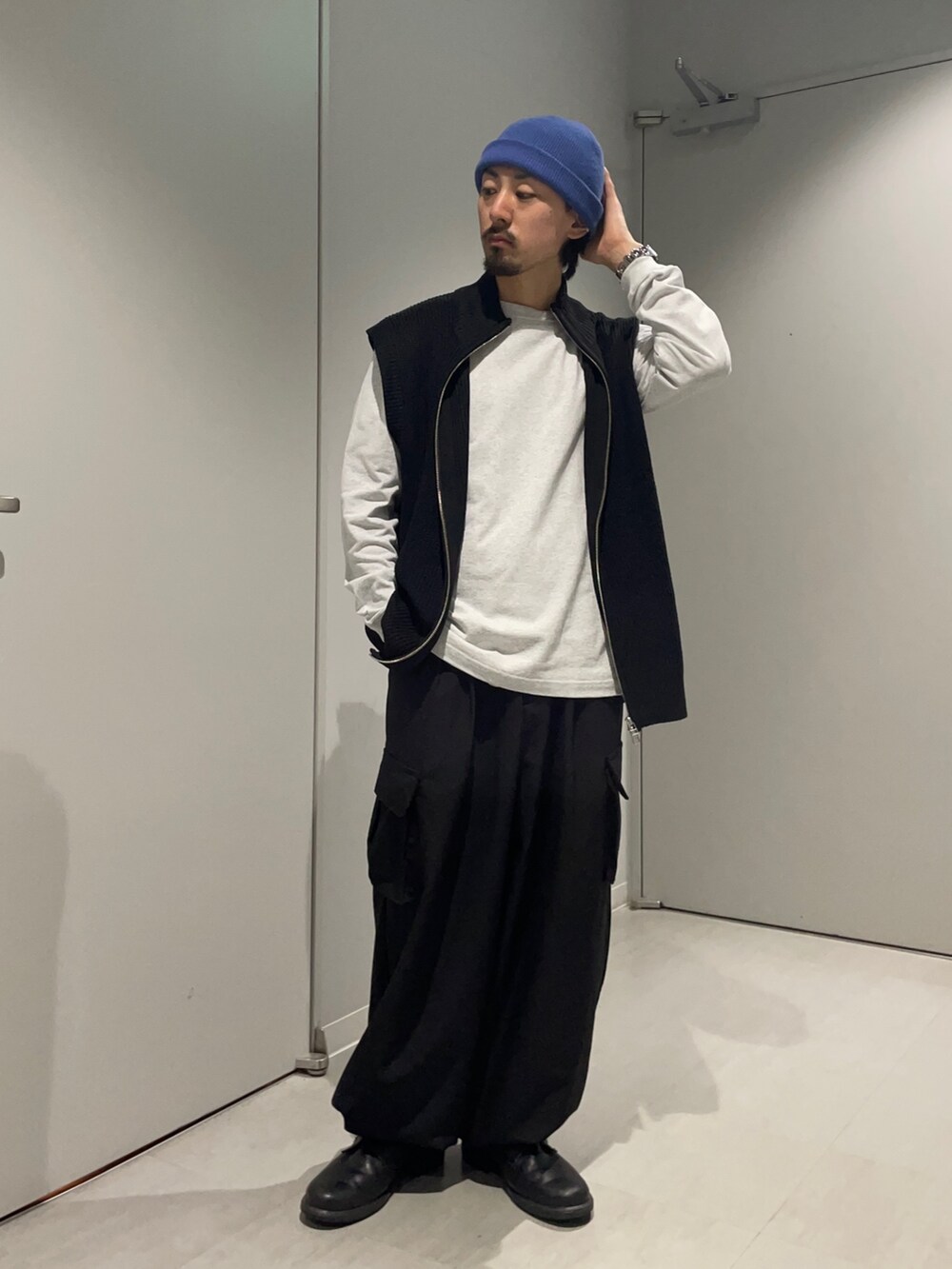 グレー系のTシャツ/カットソー、ブラック系のベスト、ブラック系のその他パンツを着用したメンズの春コーディネートの2枚目の写真