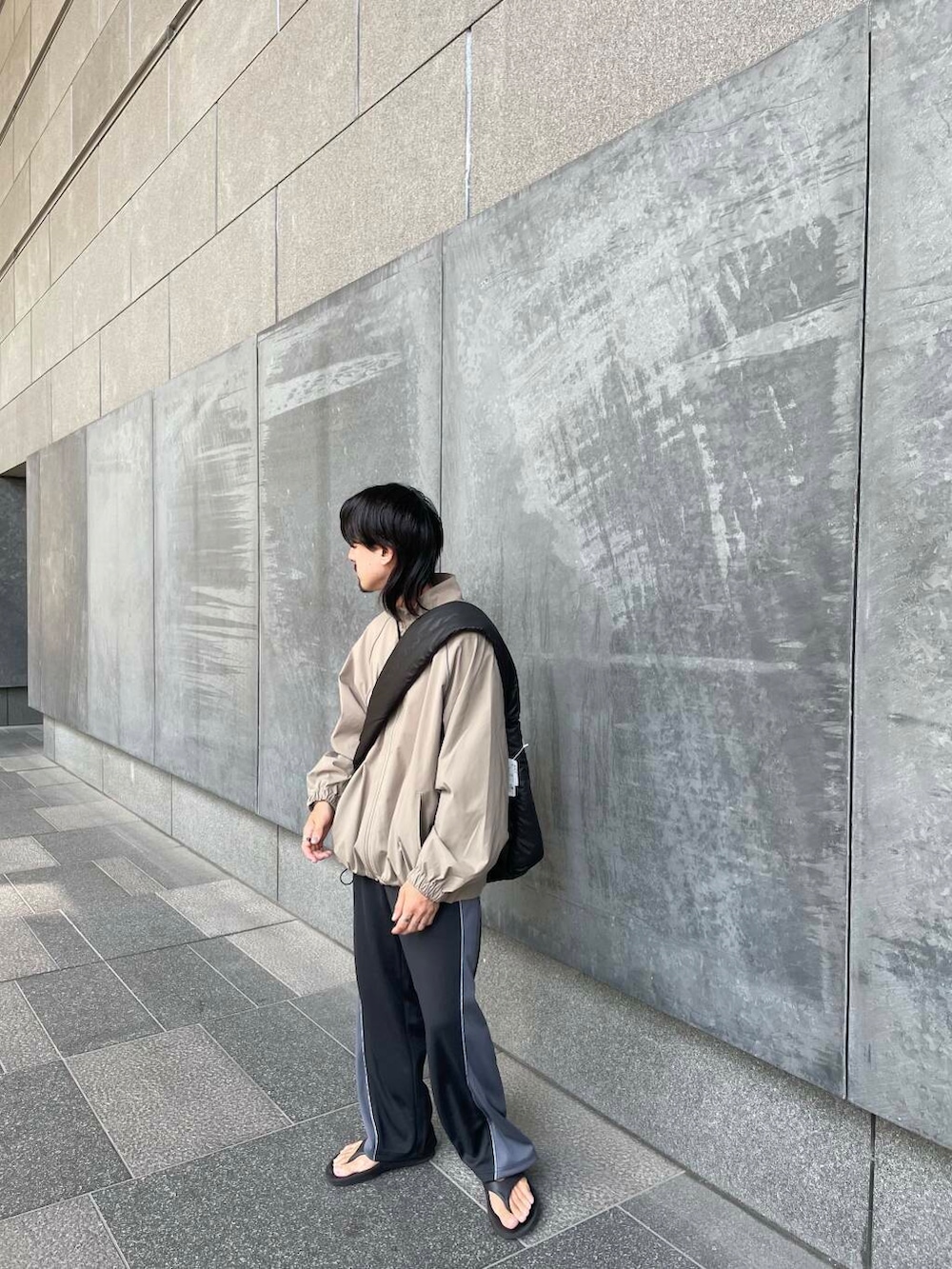 ブラック系のその他パンツ、ブラック系のショルダーバッグ、ベージュ系のブルゾンを着用したメンズの秋コーディネートの3枚目の写真