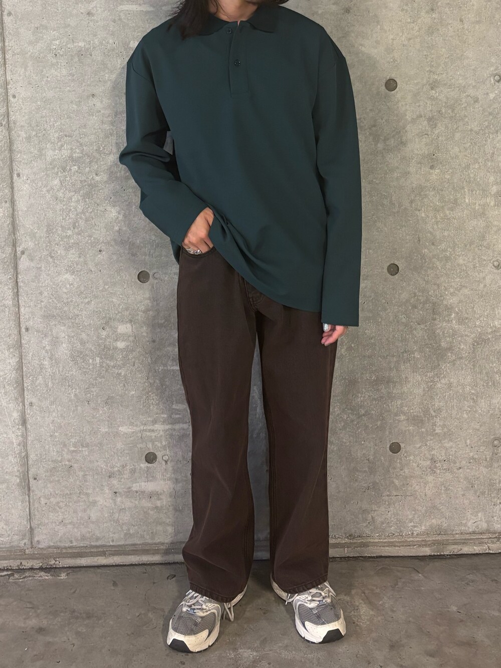 ブラウン系のデニムパンツ、グリーン系のポロシャツを着用したメンズの秋コーディネートの2枚目の写真