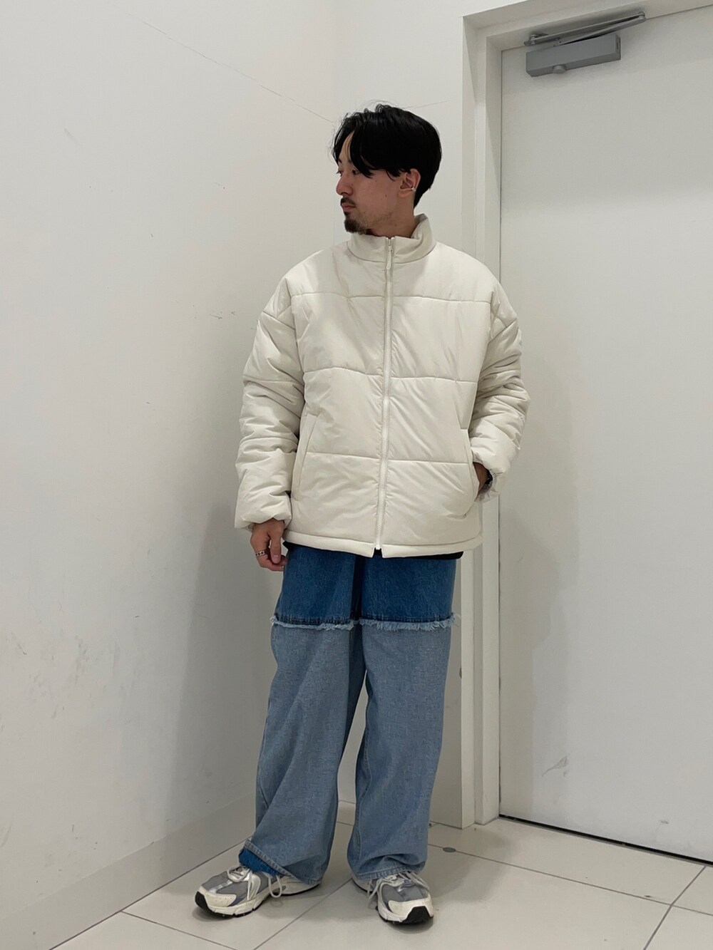 グレー系のダウンジャケット/コート、ブラック系のデニムパンツを着用したメンズの冬コーディネートの2枚目の写真