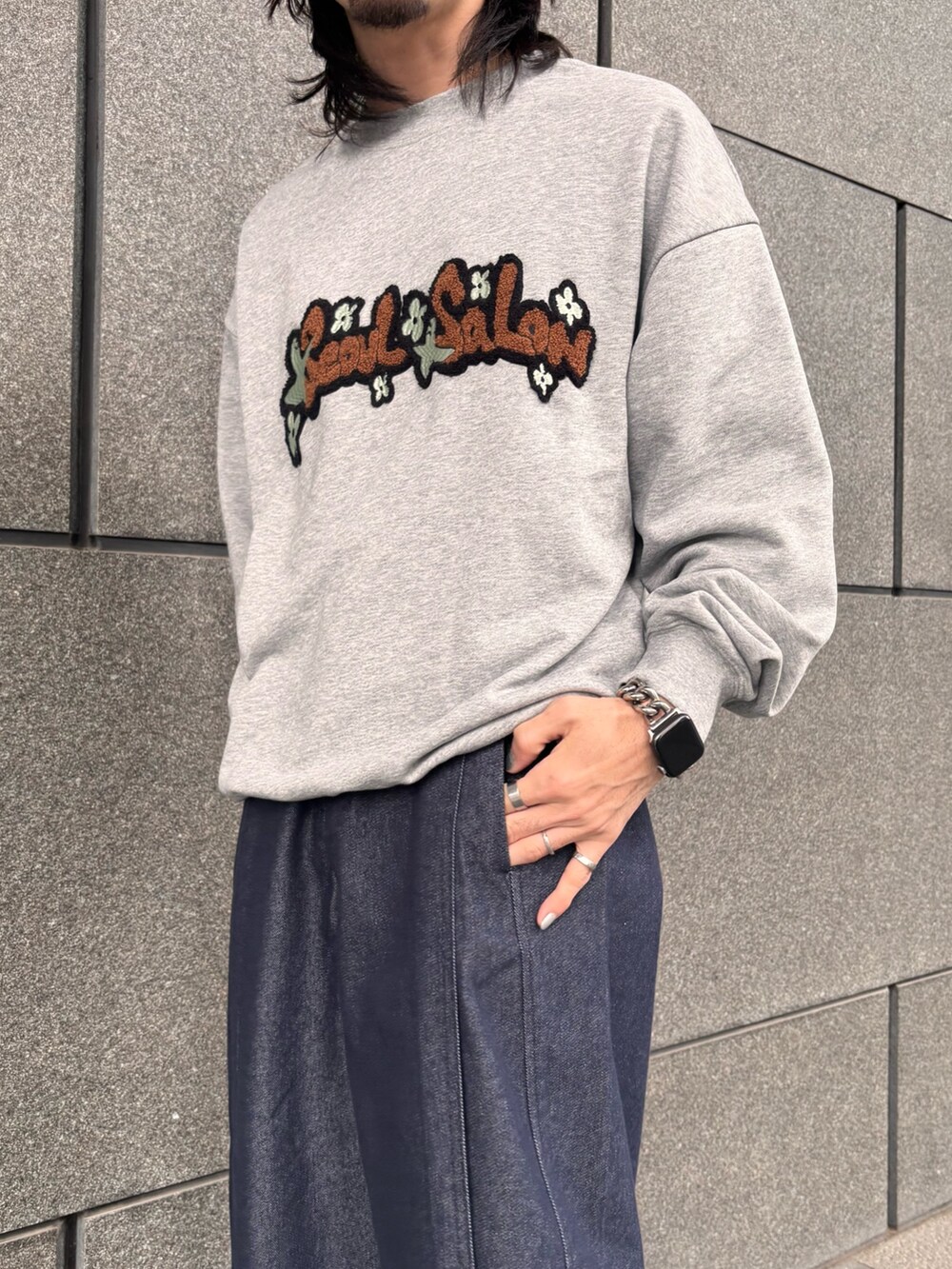 グレー系のスウェット、ブルー系のデニムパンツを着用したメンズの春コーディネートの2枚目の写真