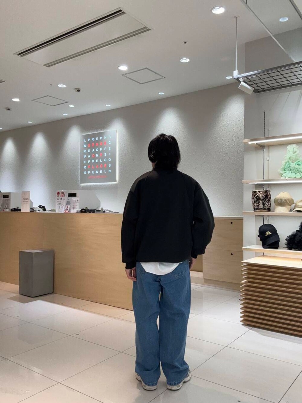 ブルー系のデニムパンツ、ブラック系のスウェットを着用したメンズの春コーディネートの4枚目の写真