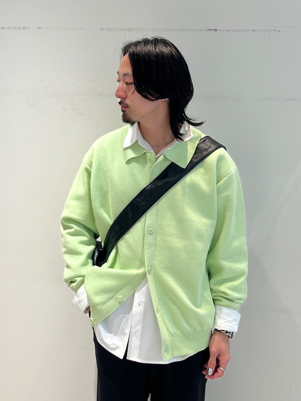 グリーン系のカーディガン/ボレロ、ホワイト系のシャツ/ブラウス、ブラック系のスラックスを着用したメンズの冬コーディネートの4枚目の写真