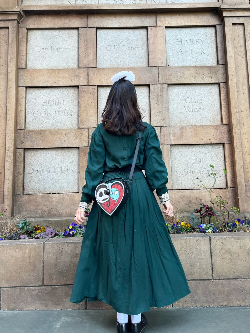 グリーン系のワンピース、ブラック系のローファーを着用したレディースの春コーディネートの2枚目の写真