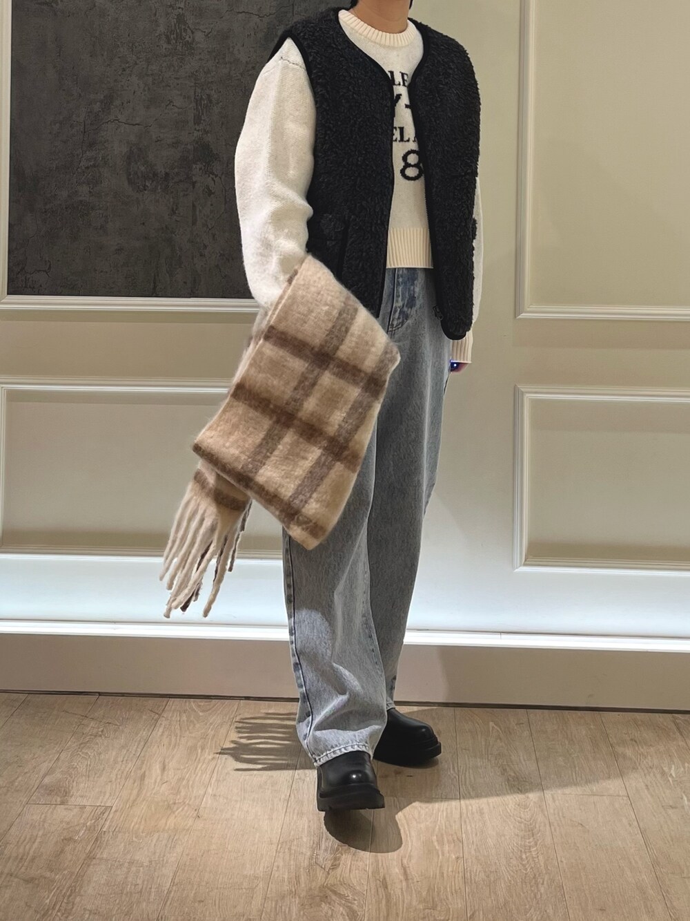 ブルー系のデニムパンツ、ホワイト系のニット/セーター、グレー系のブルゾンを着用したレディースの冬コーディネートの2枚目の写真