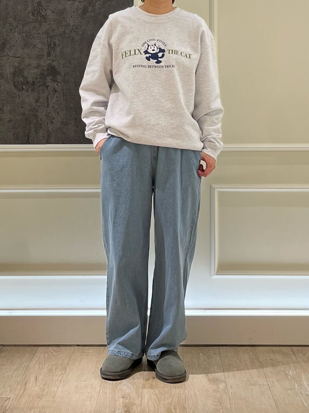 グレー系のスウェット、ブルー系のデニムパンツを着用したレディースの春コーディネートの2枚目の写真