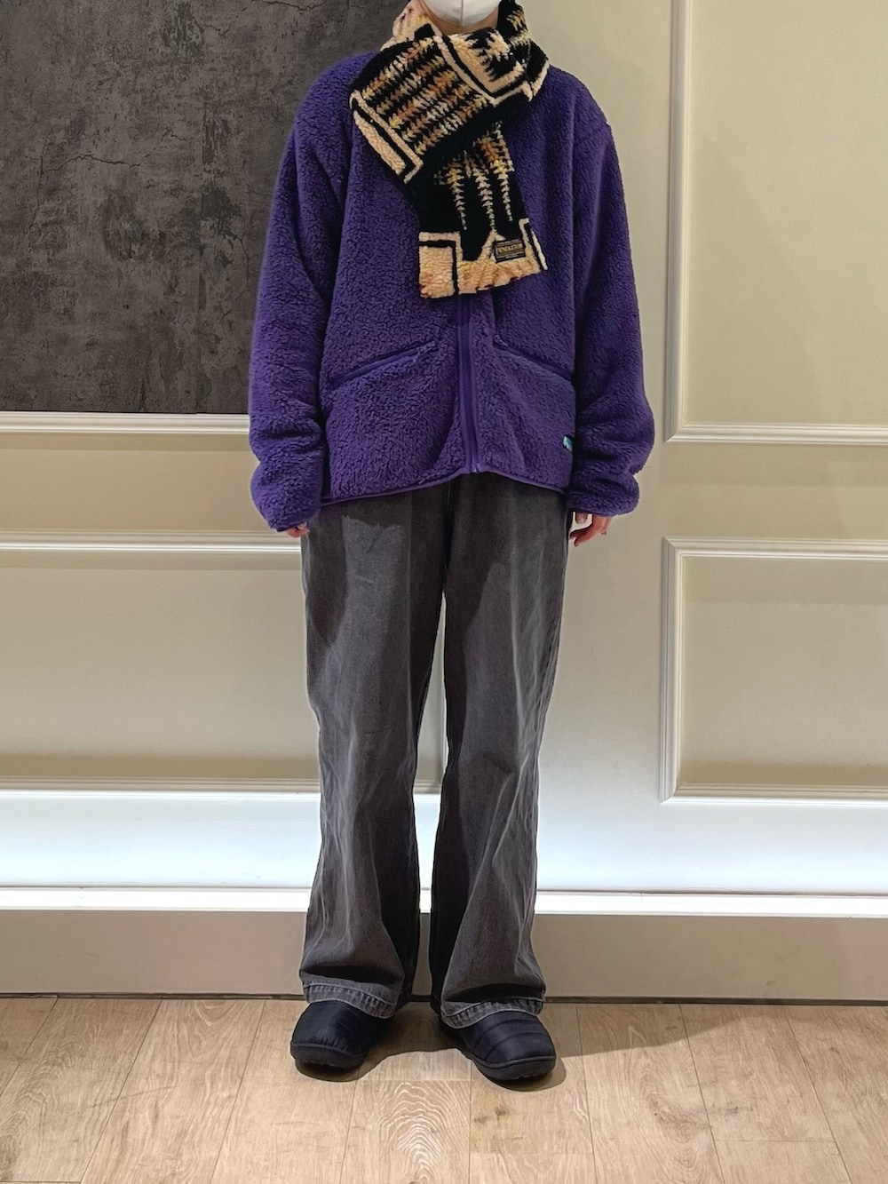 グレー系のデニムパンツ、ブラック系のサンダル、パープル系のカーディガン/ボレロを着用したレディースの秋コーディネートの2枚目の写真