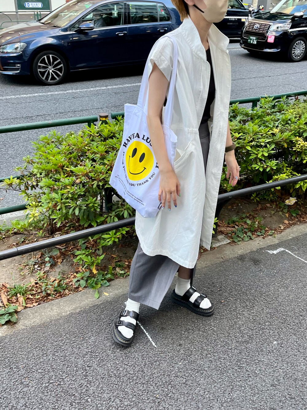 ホワイト系のベスト、ブラック系のサンダル、グレー系のスカートを着用したレディースの夏コーディネートの2枚目の写真