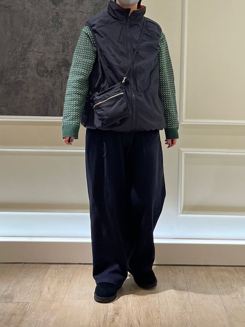 ブラック系のベスト、ブラック系のショルダーバッグ、グリーン系のニット/セーターを着用したレディースの冬コーディネートの2枚目の写真