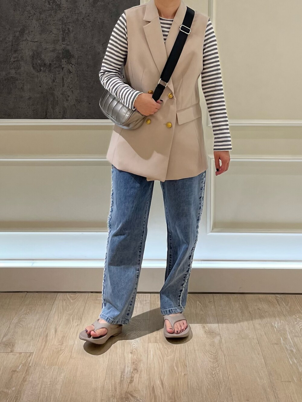 ブルー系のデニムパンツ、シルバー系のショルダーバッグ、グレー系のTシャツ/カットソーを着用したレディースの夏コーディネートの2枚目の写真