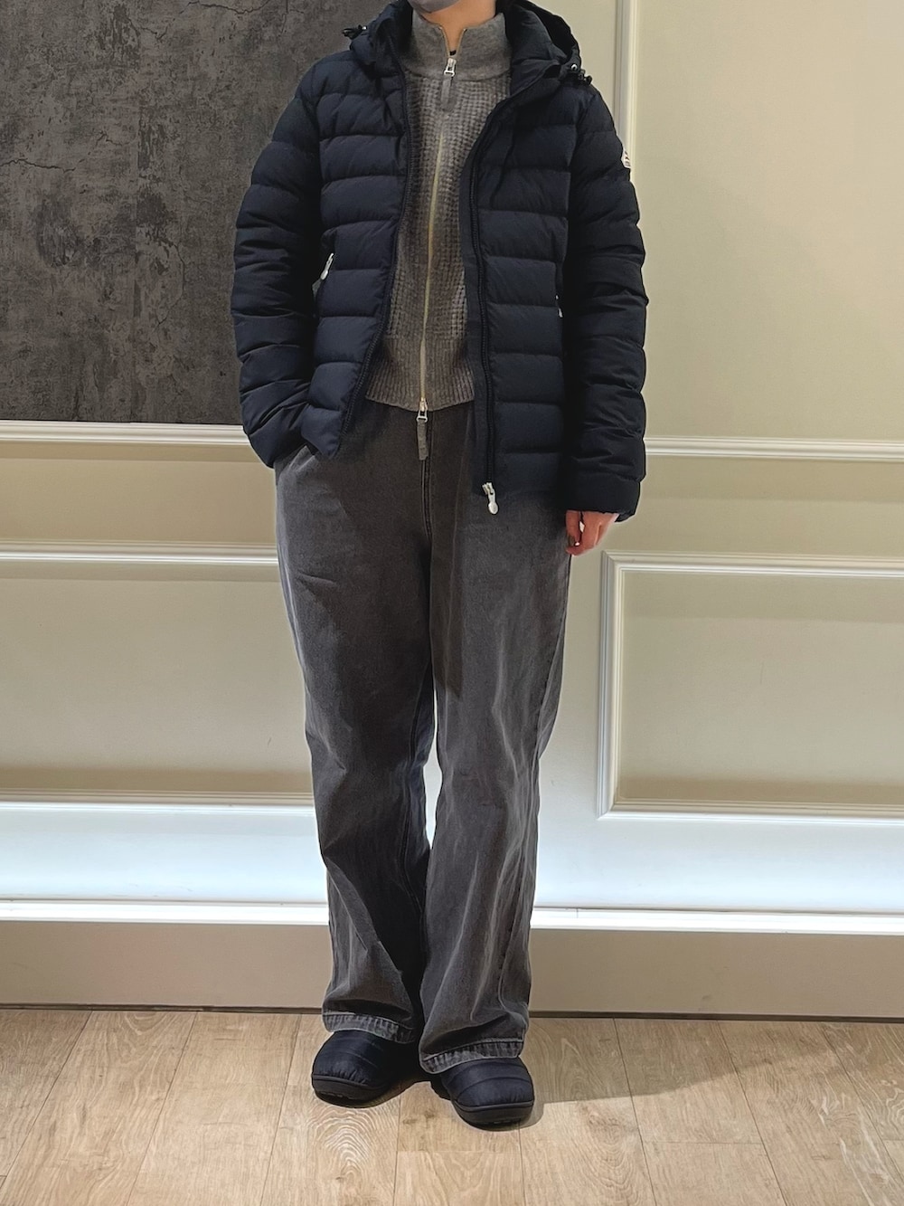 ブラック系のダウンジャケット/コート、グレー系のデニムパンツ、ブラック系のサンダルを着用したレディースの冬コーディネートの2枚目の写真