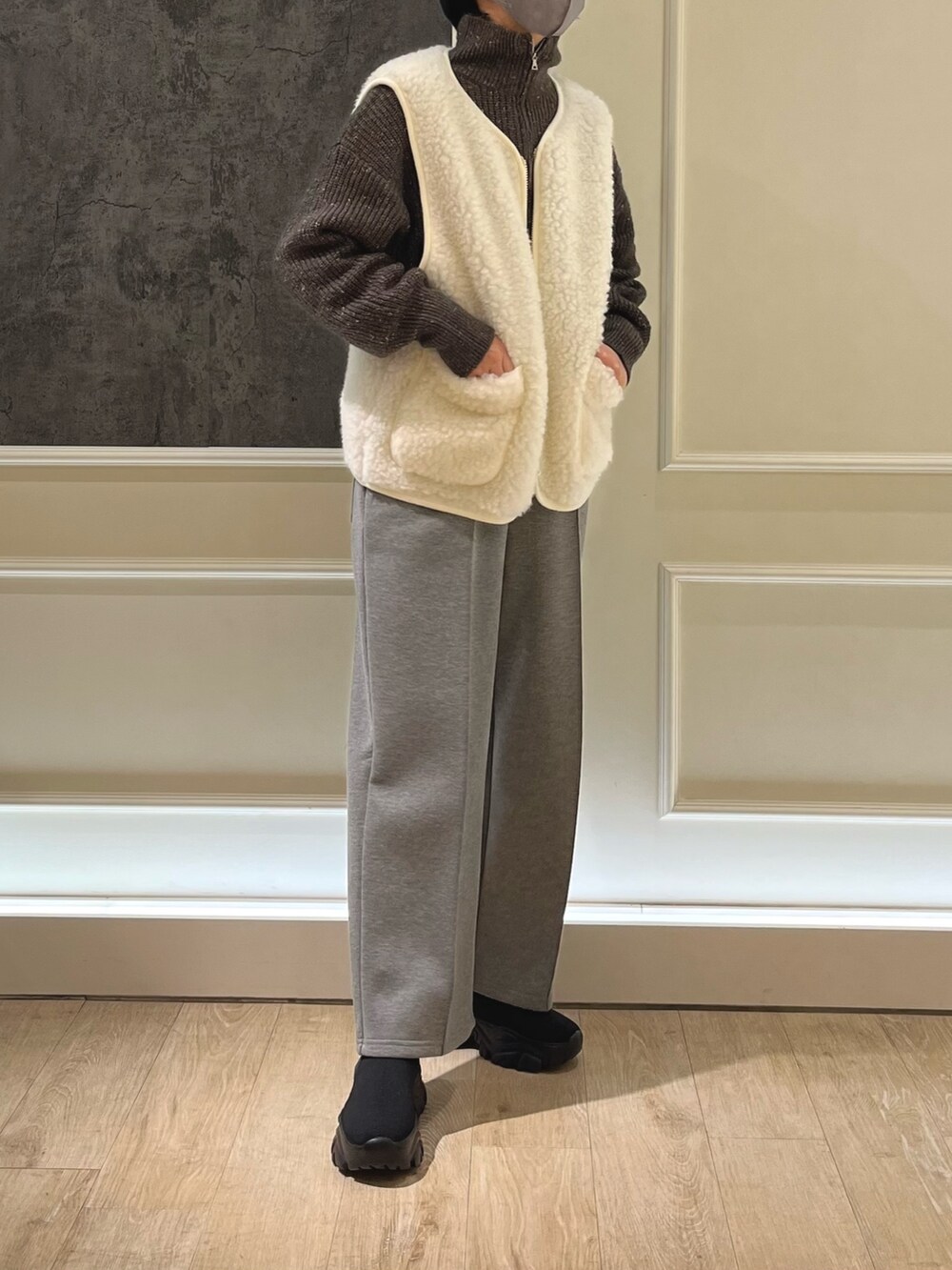グレー系のその他パンツ、ブラック系のブーツ、グレー系のニット/セーターを着用したレディースの冬コーディネートの2枚目の写真