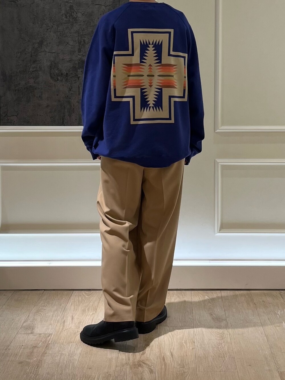 ベージュ系のスラックス、ブルー系のスウェットを着用したレディースの秋コーディネートの2枚目の写真