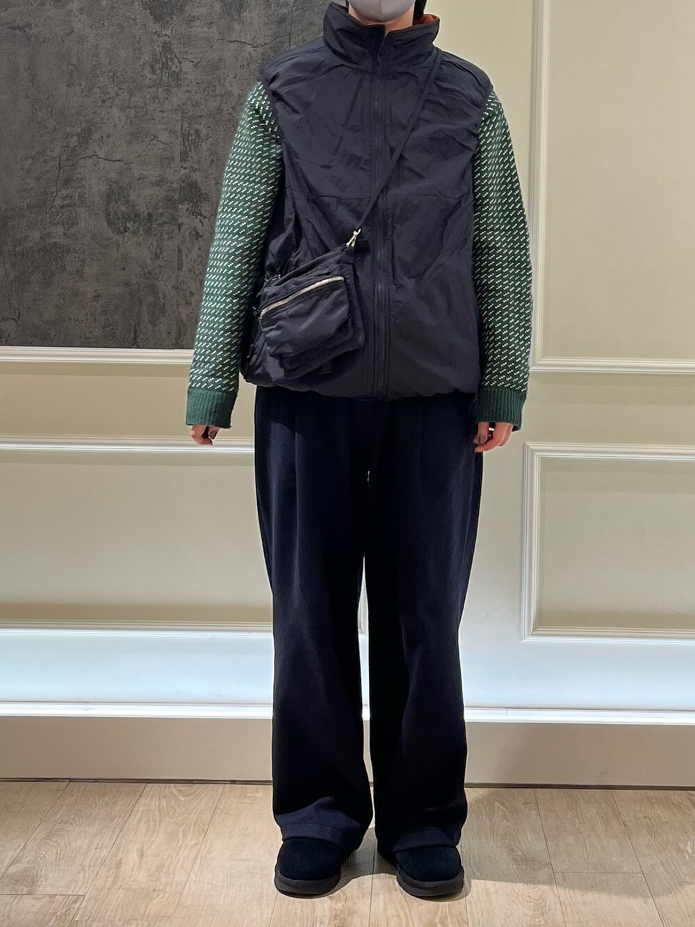 ブラック系のベスト、ブラック系のショルダーバッグ、グリーン系のニット/セーターを着用したレディースの冬コーディネートの3枚目の写真