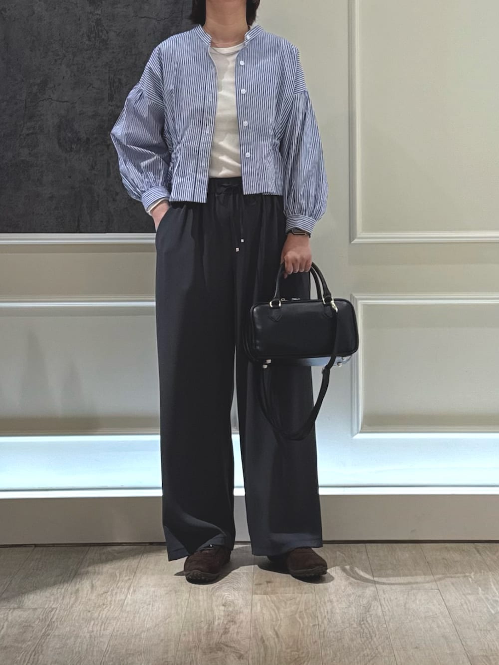 ブルー系のシャツ/ブラウス、グレー系のその他パンツ、ブラック系のショルダーバッグを着用したレディースの春コーディネートの2枚目の写真