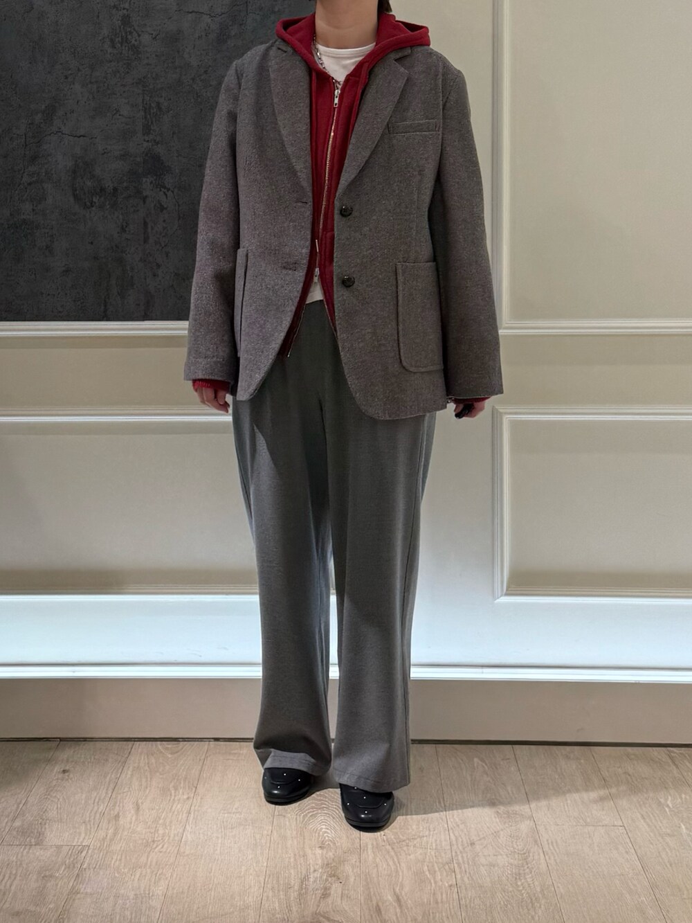 ブラウン系のテーラードジャケット、グレー系のその他パンツ、レッド系のパーカーを着用したレディースの冬コーディネートの2枚目の写真