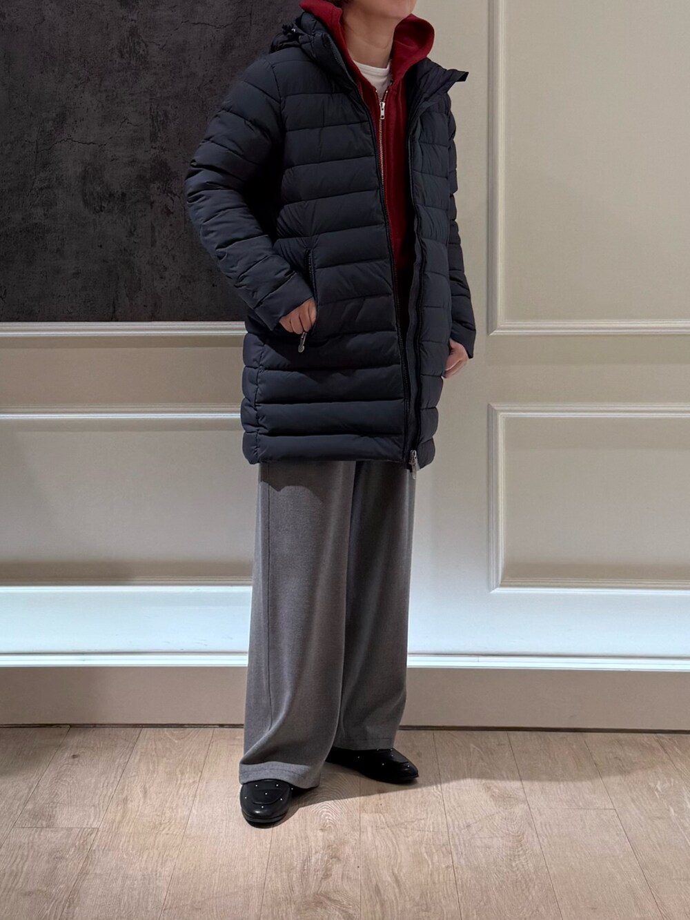 グレー系のダウンジャケット/コート、レッド系のパーカー、グレー系のその他パンツを着用したレディースの秋コーディネートの2枚目の写真