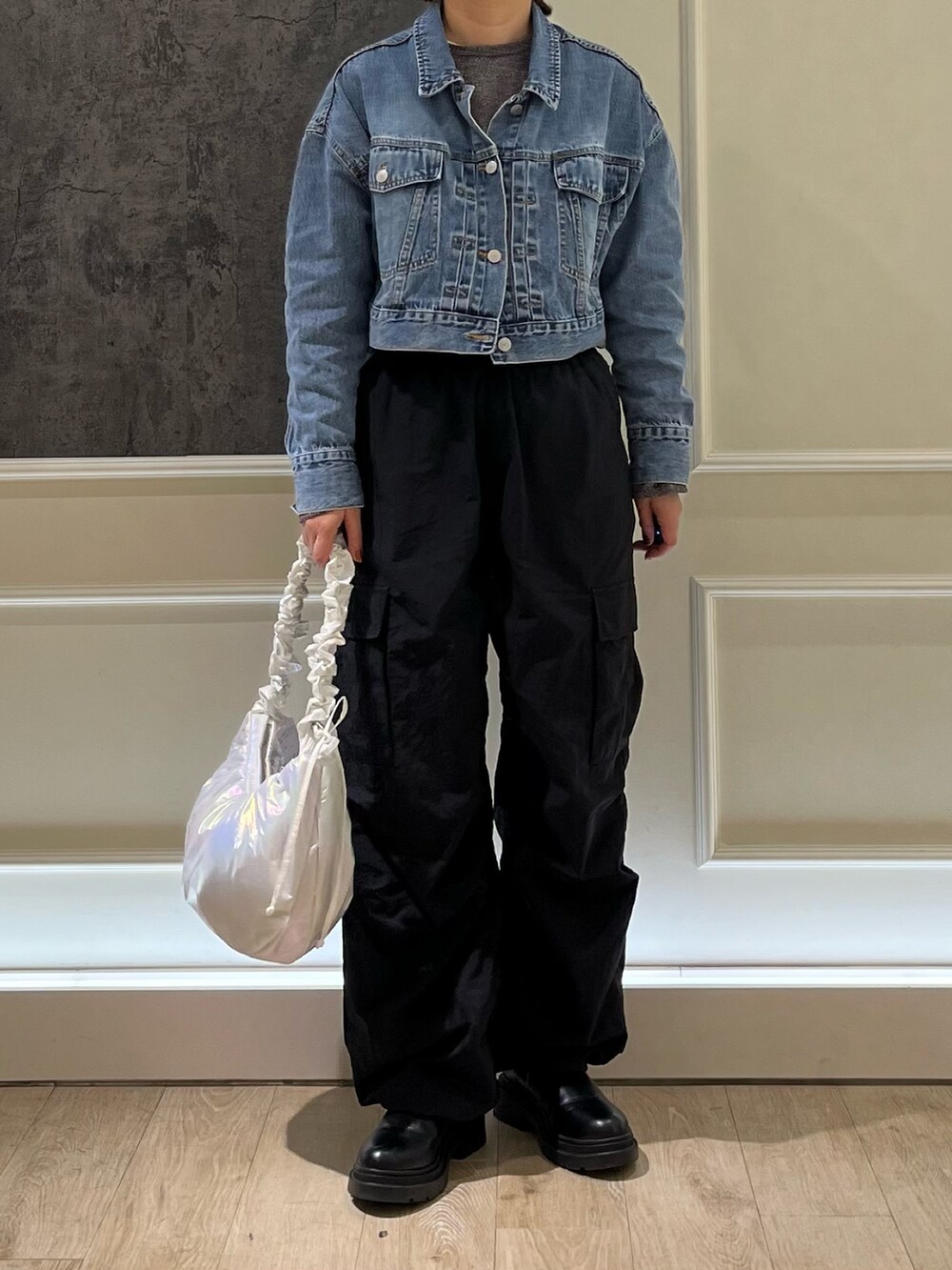 ブラック系のカーゴパンツ、ブルー系のデニムジャケット、ホワイト系のショルダーバッグを着用したレディースの春コーディネートの2枚目の写真