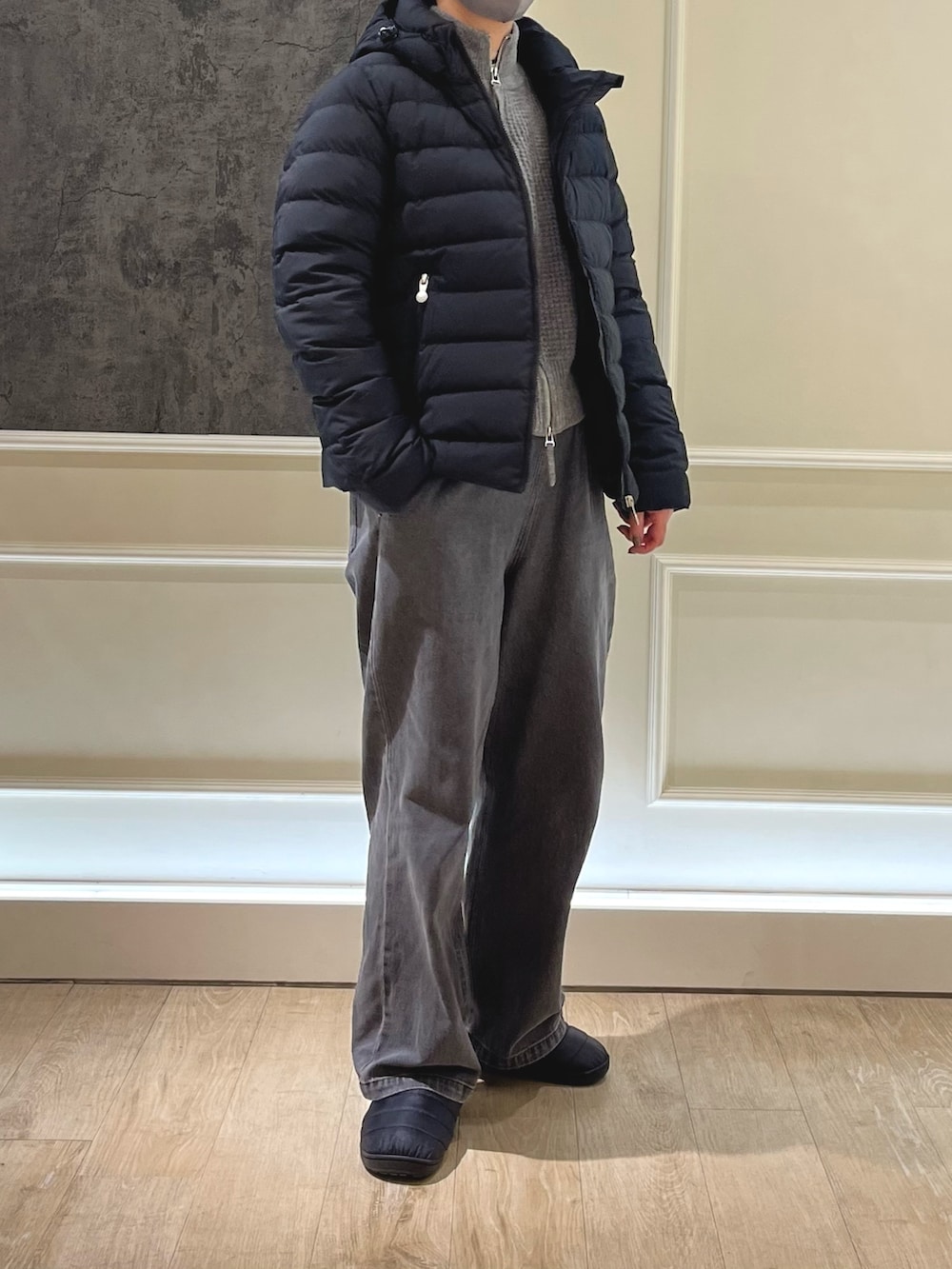 ブラック系のダウンジャケット/コート、グレー系のデニムパンツ、ブラック系のサンダルを着用したレディースの冬コーディネートの3枚目の写真