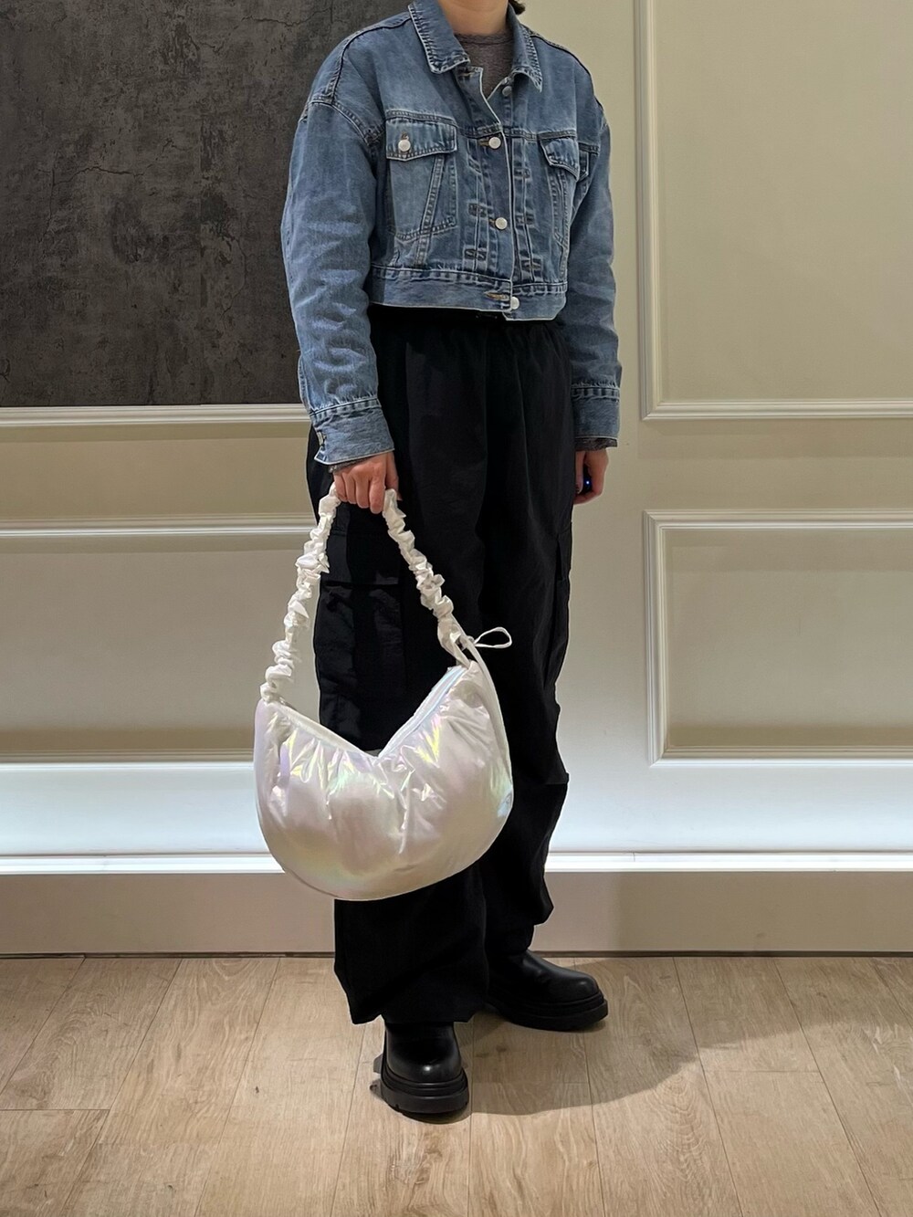 ブラック系のカーゴパンツ、ブルー系のデニムジャケット、ホワイト系のショルダーバッグを着用したレディースの春コーディネートの3枚目の写真