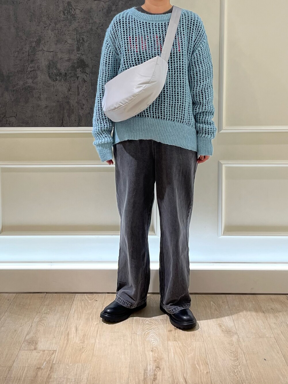 グレー系のデニムパンツ、グレー系のショルダーバッグ、ブラック系のTシャツ/カットソーを着用したレディースの秋コーディネートの2枚目の写真