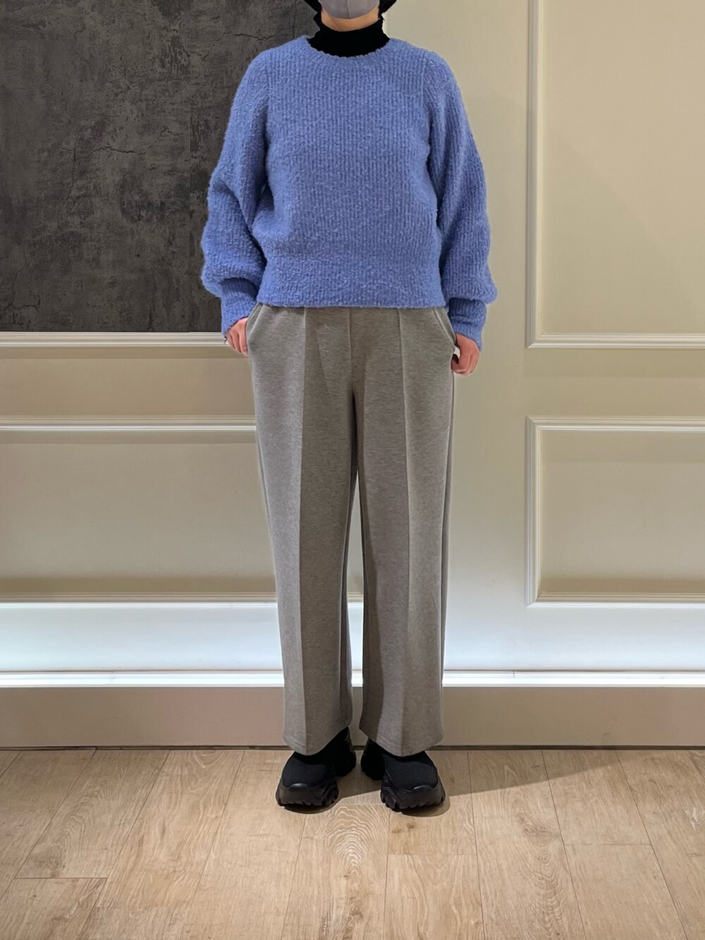 ブラック系のブーツ、ブラック系のTシャツ/カットソー、ブルー系のニット/セーターを着用したレディースの冬コーディネートの2枚目の写真